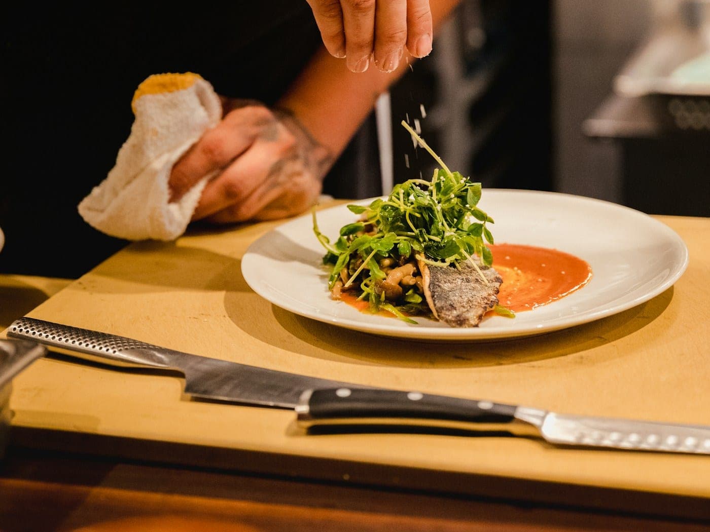Chef finishing a plate with herb oil