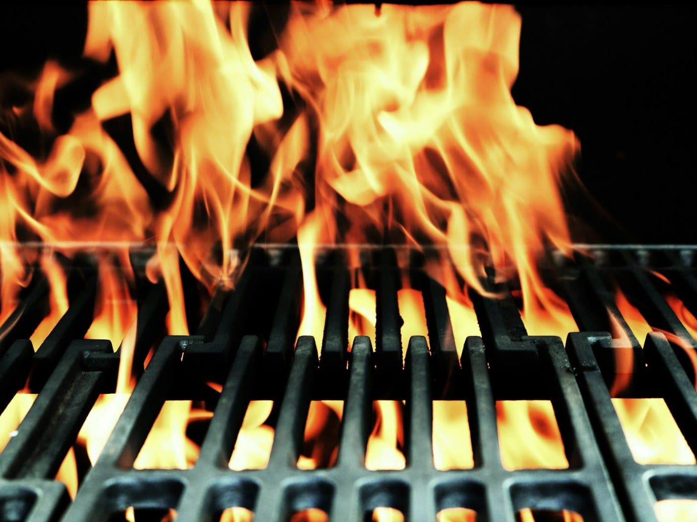 Close view of steak searing over glowing charcoal